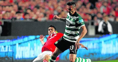 El lateral zurdo del Benfica Lorenzo Melgarejo trata de frenar el avance de Miguel Lopes en un partido de la 12/13.